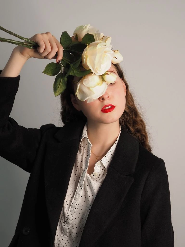 Fleuriste diplômée composant un bouquet de pivoines à l'atelier.